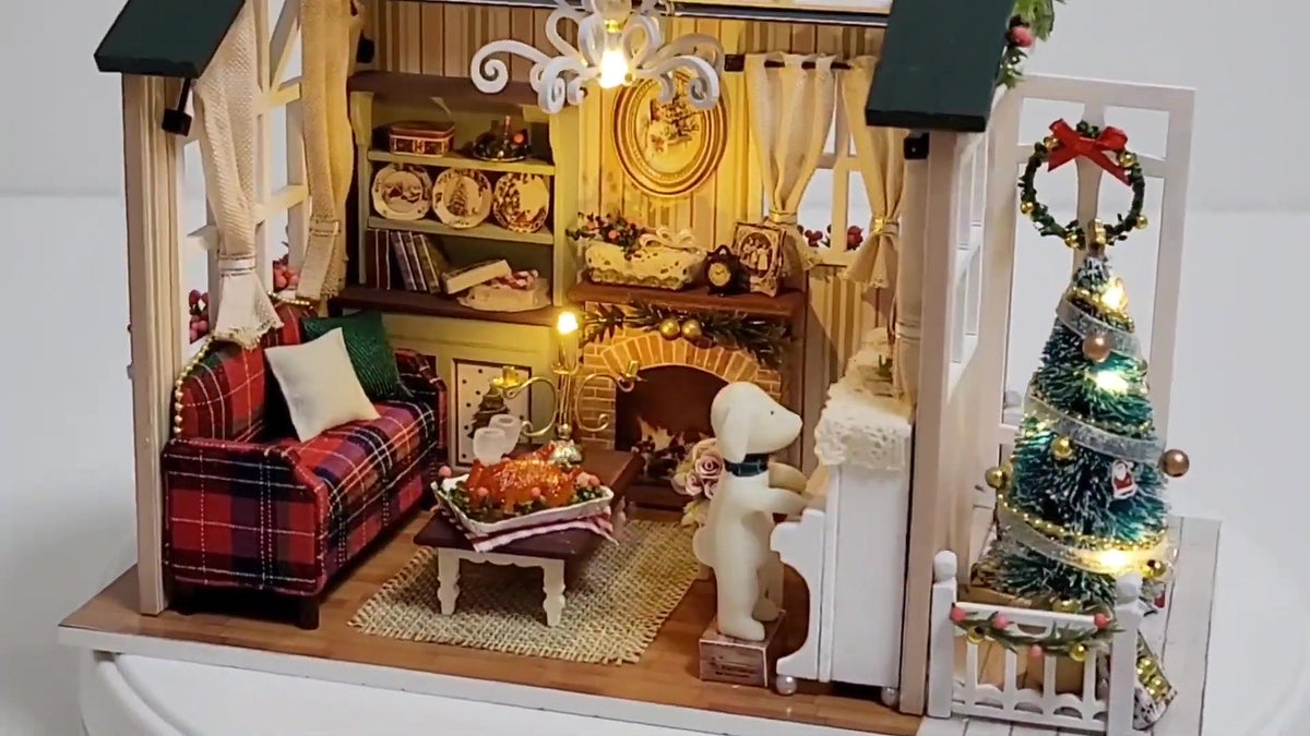 Inside the lit Christmas Cabin miniature: plaid sofa, fireplace, tree and pup at the piano